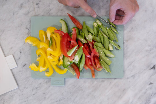 Aerial view of man cutting vegetables on marble stove