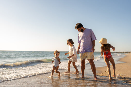 A family playing together on the beach at golden time.