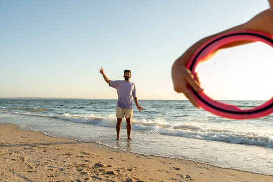 A family playing frisbee on the beach at golden time.