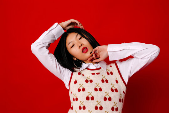 Model tilting head in red studio