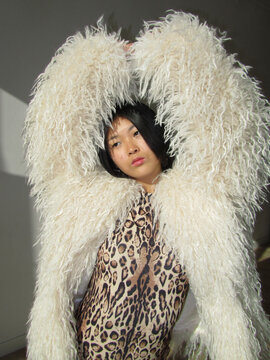Woman posing with raised fur-covered arms