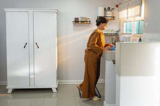 Woman washing dishes in the kitchen