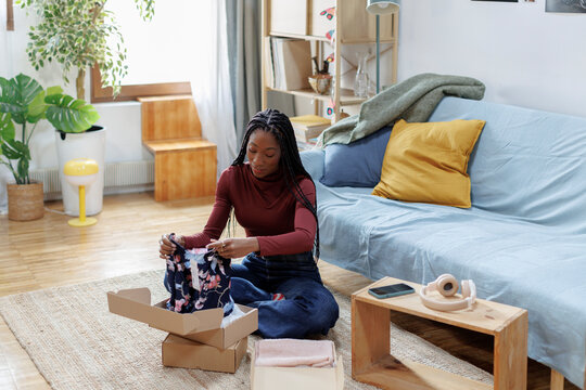 Woman at home opening recent purchases online