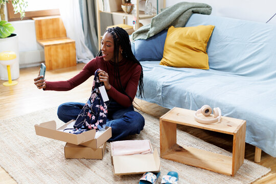 Woman at home opening recent purchases online while doing video chat