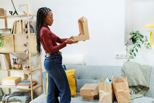 Woman at home opening shopping bags and boxes at home