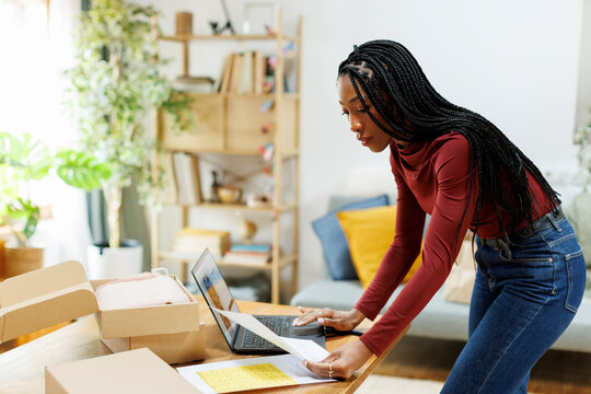 Woman entrepreneur organizing packages to deliver from home office