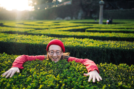 Woman Enjoying an Adventure in a Green Maze