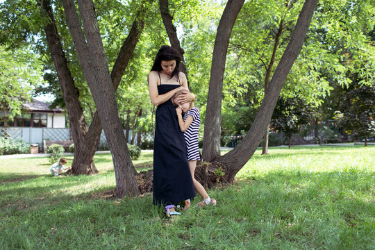 mother and daughter are standing in the park