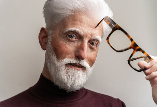 Playful Albino Senior Man Holding Glasses

