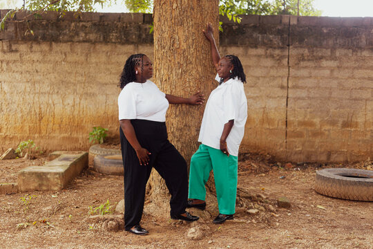 Mother and daughter holding onto a tree
