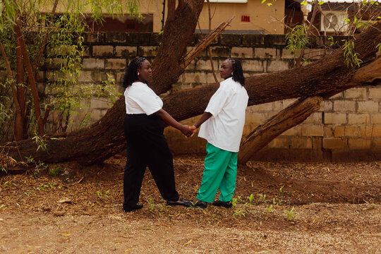 Mother and Daughter posing in front of a tree