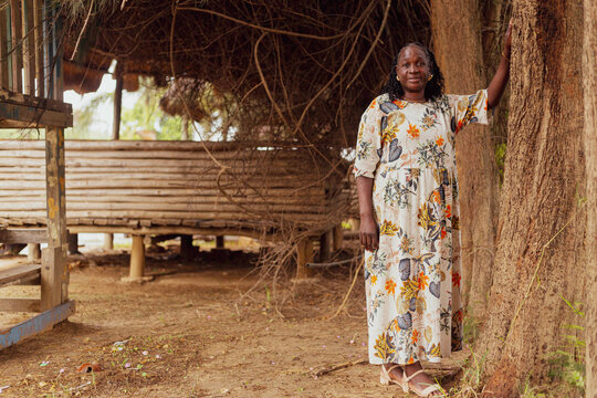 Portrait of elderly woman holding a tree