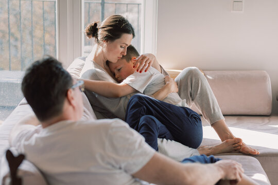 Mother Comforting Child in Sunlit Living Room