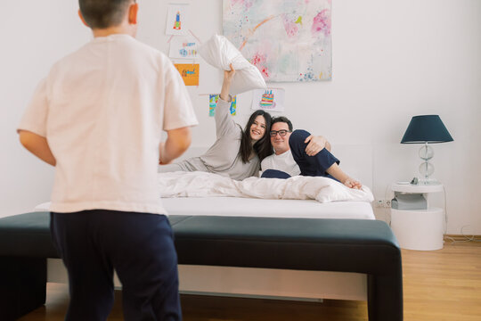 Family Enjoying a Playful Moment in a Cozy Bedroom Setting