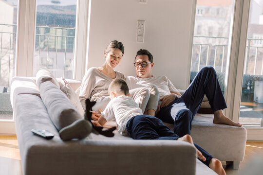Family relaxing together on a sunlit couch