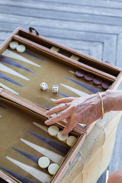 Hand moving a checker piece in a Backgammon board game