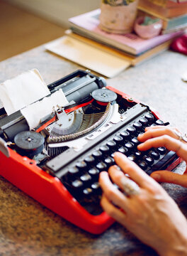 Woman Typing on a Vintage Red Typewriter in a cosy interior 2