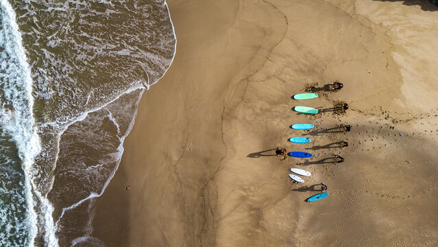 Aerial view of surfers on Buggerru beach, Sardinia: Sport and wild nature