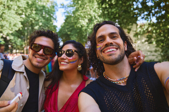 Friends taking a selfie while celebrating Pride with smiles and style