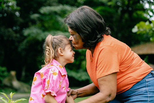 Grandmother Kissing Granddaughter's Forehead