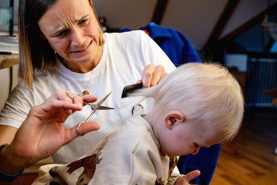 Mother cutting childs hair 