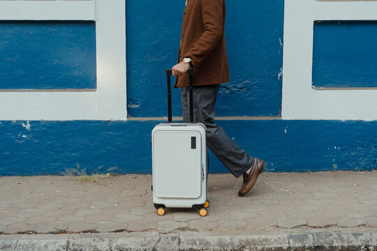 Man carrying a suitcase while Traveling on Foot