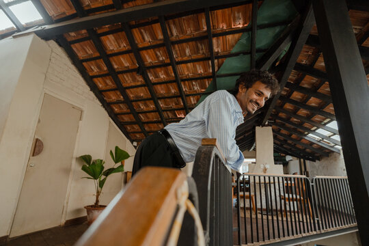 Man Leaning Over the Balcony with a Smile