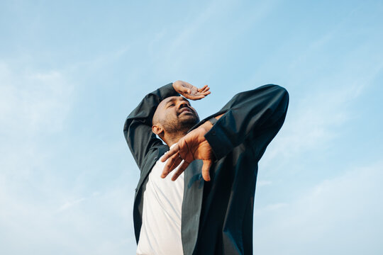 Man Enjoying Outdoor Dance Performance Under Blue Sky