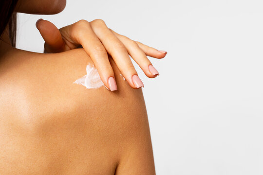 Woman Hand Applying Cream to Shoulder