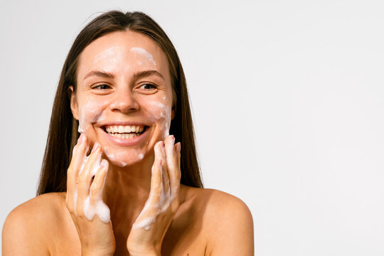 Woman Smiling While Applying Cream. Skincare