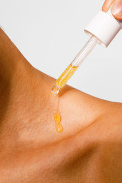 Golden Oil Dripping on Woman&rsquo;s Skin