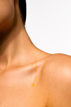 Woman Golden Oil Dripping on Shoulder