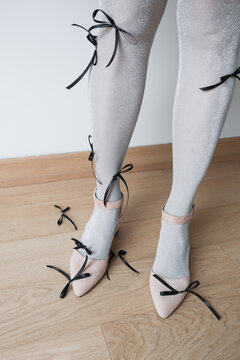 Fashionable footwear and unique styling with ribbons on silvery tights