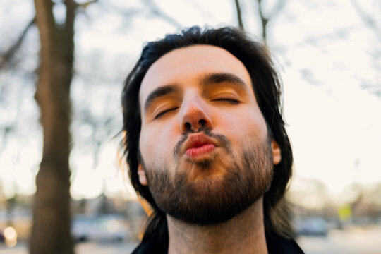 Candid portrait of man making kiss face at Camera