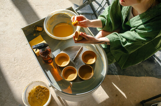 hands of a master ceramist with dishes