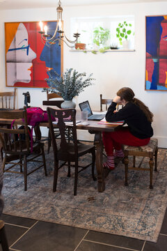 Girl working on her homework at the kitchen table