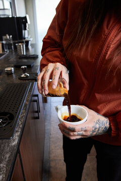Barista Pouring Freshly Brewed Coffee into a Cupping Bowl