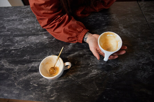 Anonymous hand holding an empty coffee cup
