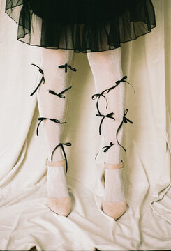 Unique fashion statement with black bows adorning white stockings