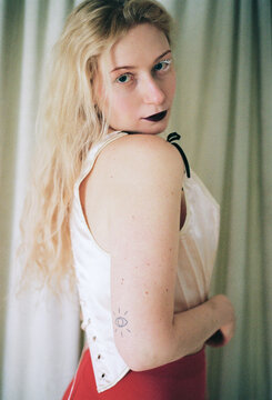 Stylish young woman poses in a shimmering corset with dramatic makeup 