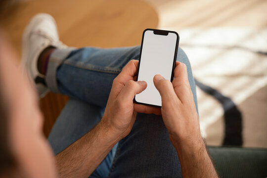 Anonymous man texting on phone with blank screen .