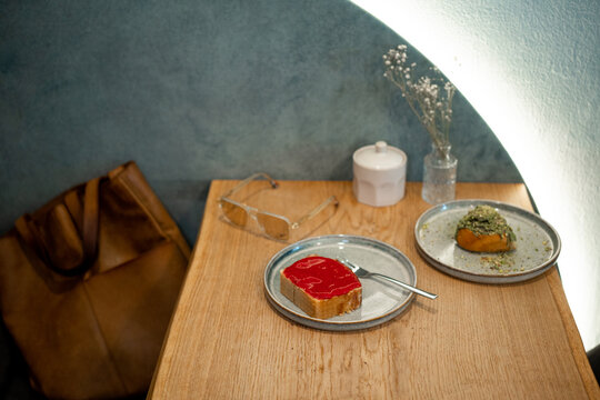 Pistachio roll and red cake on plates in  small cafe 
