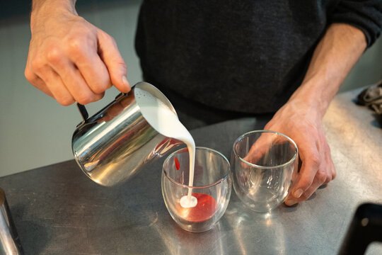 Hands preparing raspberry matcha  