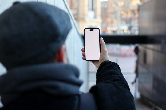 Person Holding Smartphone in Urban Setting