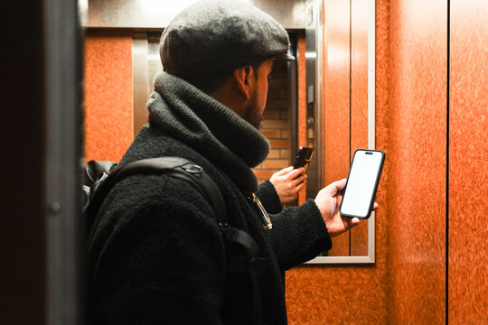 Anonymous male model looking cellphone in mirrored room