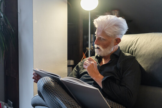 Senior Man Reading And Reflecting