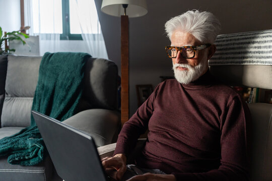 Senior Man Focused on Laptop at Home