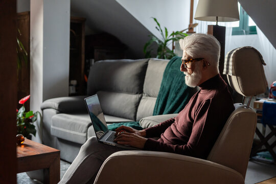 Senior Man Working on Laptop in Cozy Home