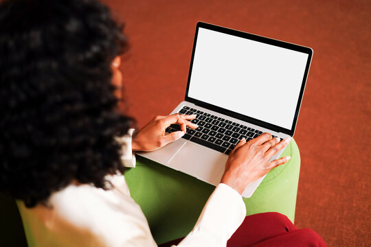 Woman working on laptop with white screen mockup 