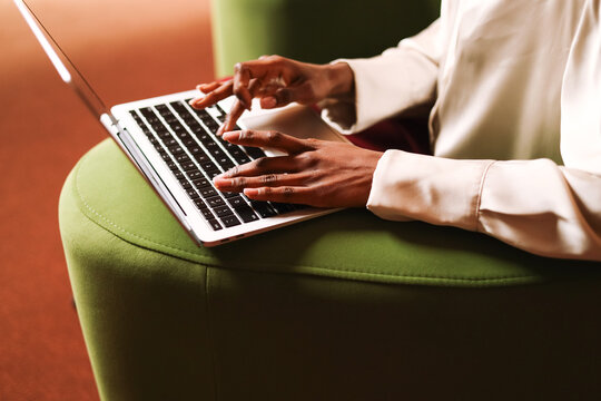 Close-up of hands working on laptop in modern workspace office